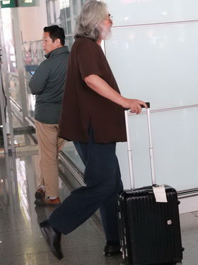 组图:66岁张纪中墨镜遮面 自拎行李老当益壮