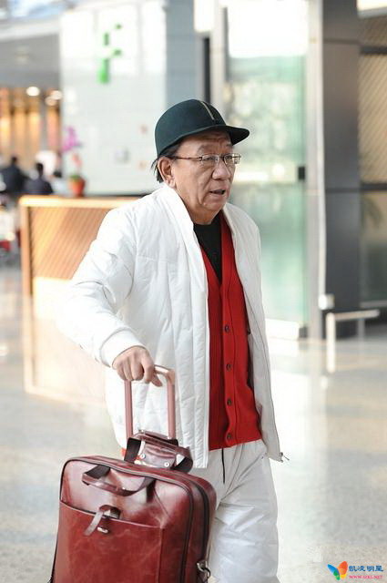 72岁侯耀华现身机场 头戴绿帽穿红衣精神好