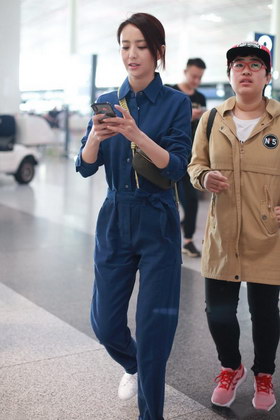 组图:佟丽娅机场变手机控消息回不停 深蓝色连衣裤显干练